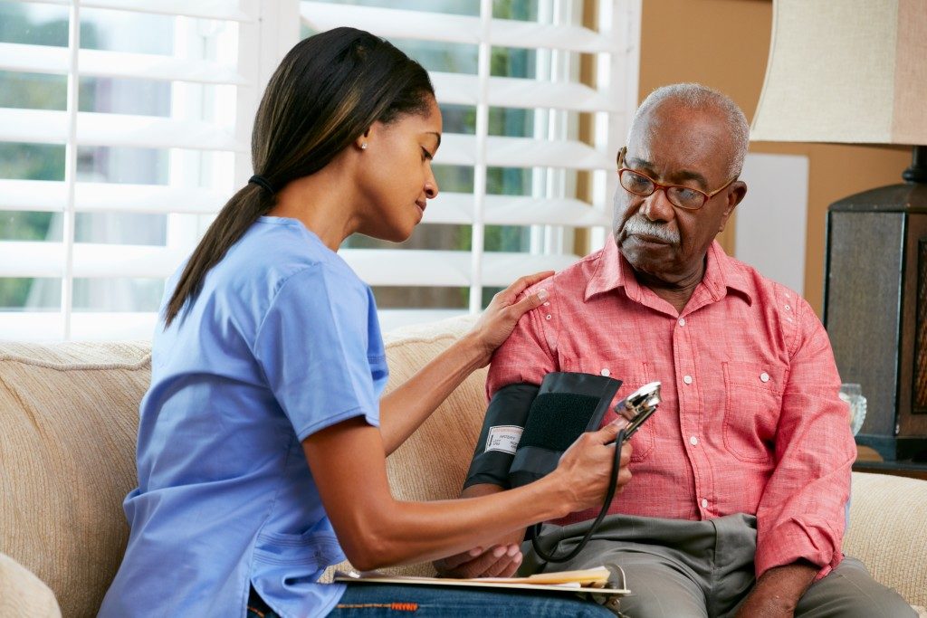 Nurse checking blood pressure of elderly