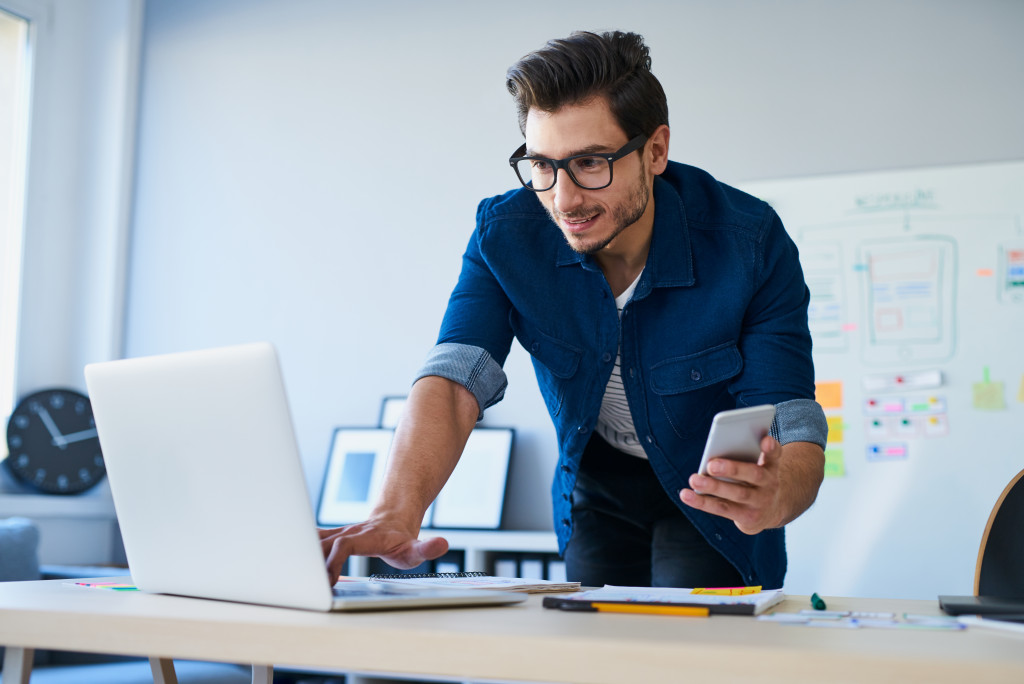 Man using laptop and phone