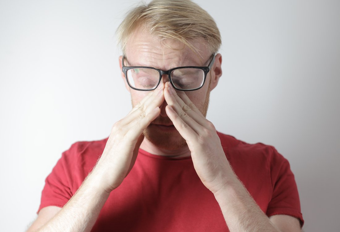 man rubbing nose bridge and getting anxious