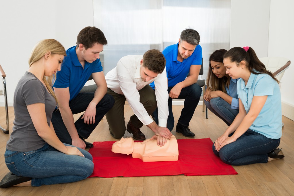 group of people practicing cpr on a dummy