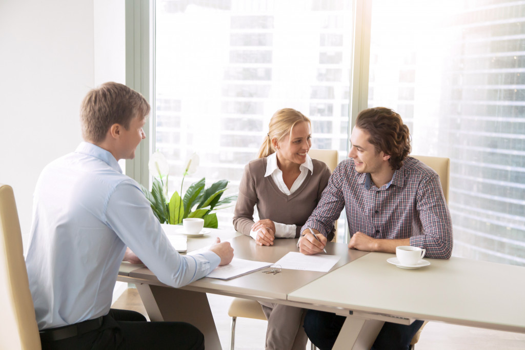 Couple talking with a financing executive to get a business loan.