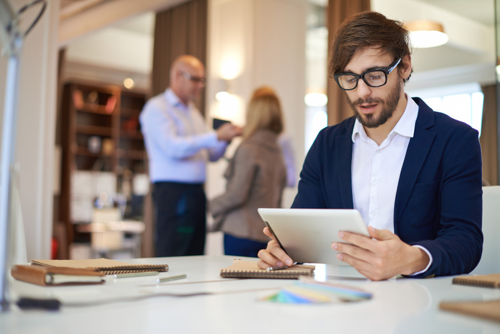 Handsome businessman in casual networking on background of his partners