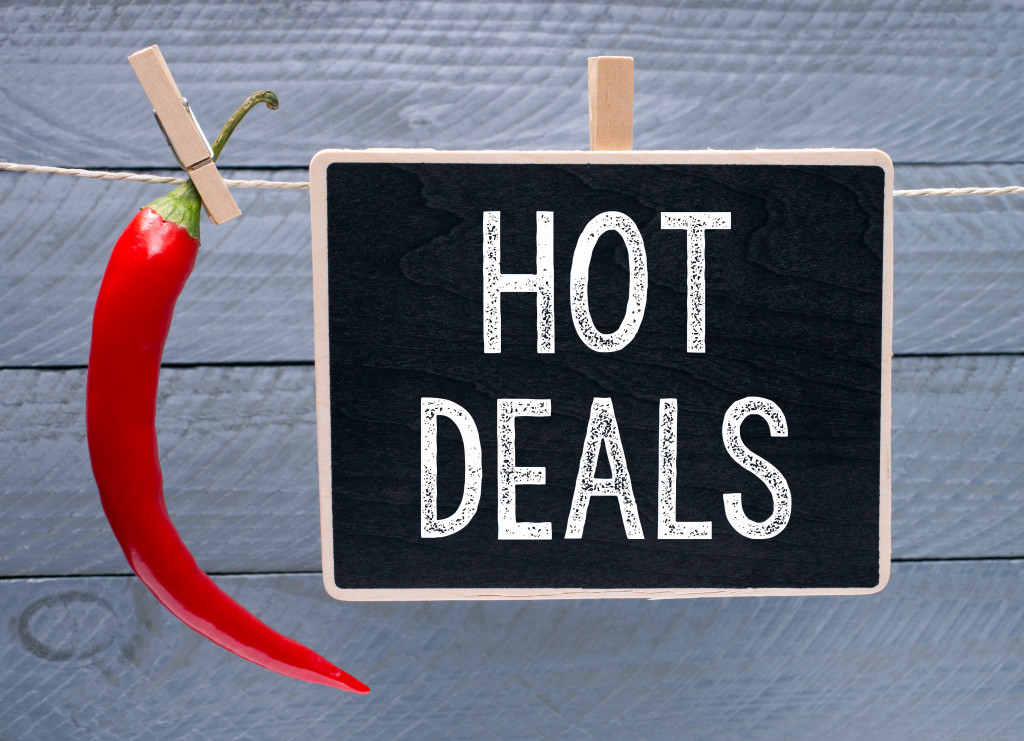 hot deals in a black board with chili in the side with wood background