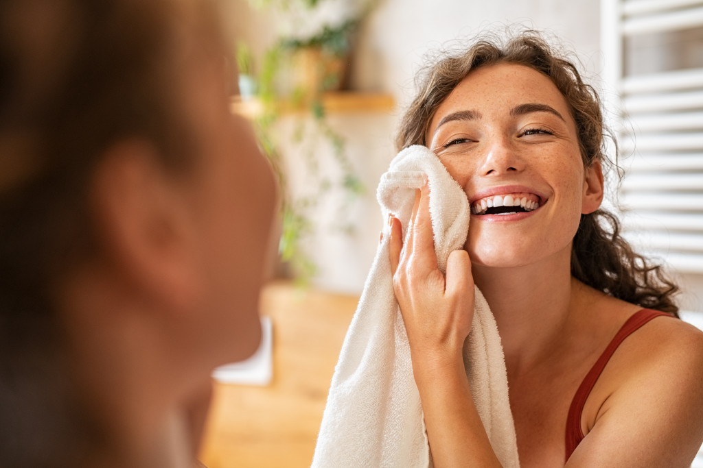 woman wiping her face with towel